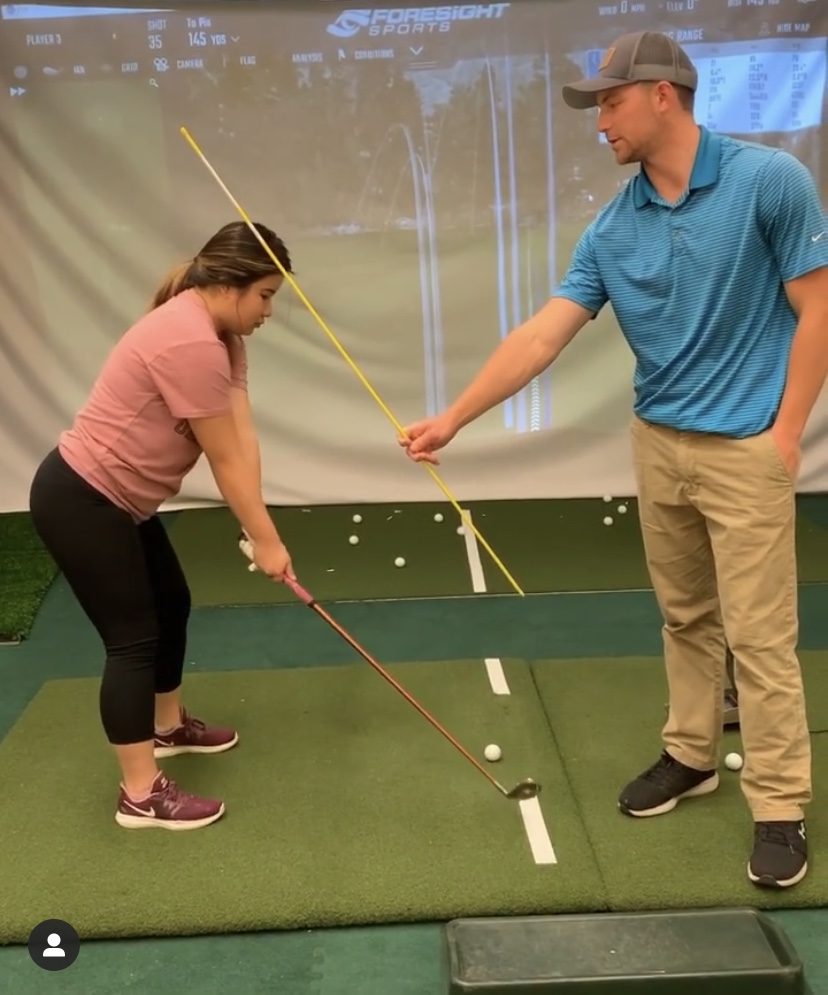 Henry Fall gives a women's golf lesson while at Bates College in Lewiston, Maine.