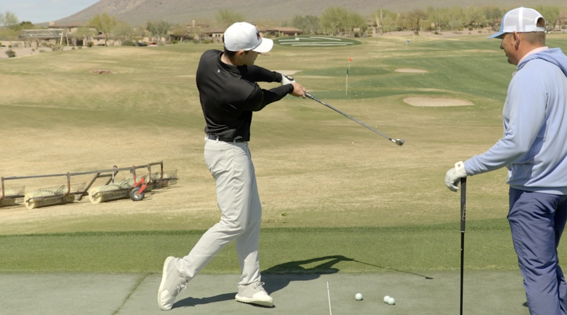 Henry Fall giving a golf lesson to Milo Lines in Phoenix, Arizona.
