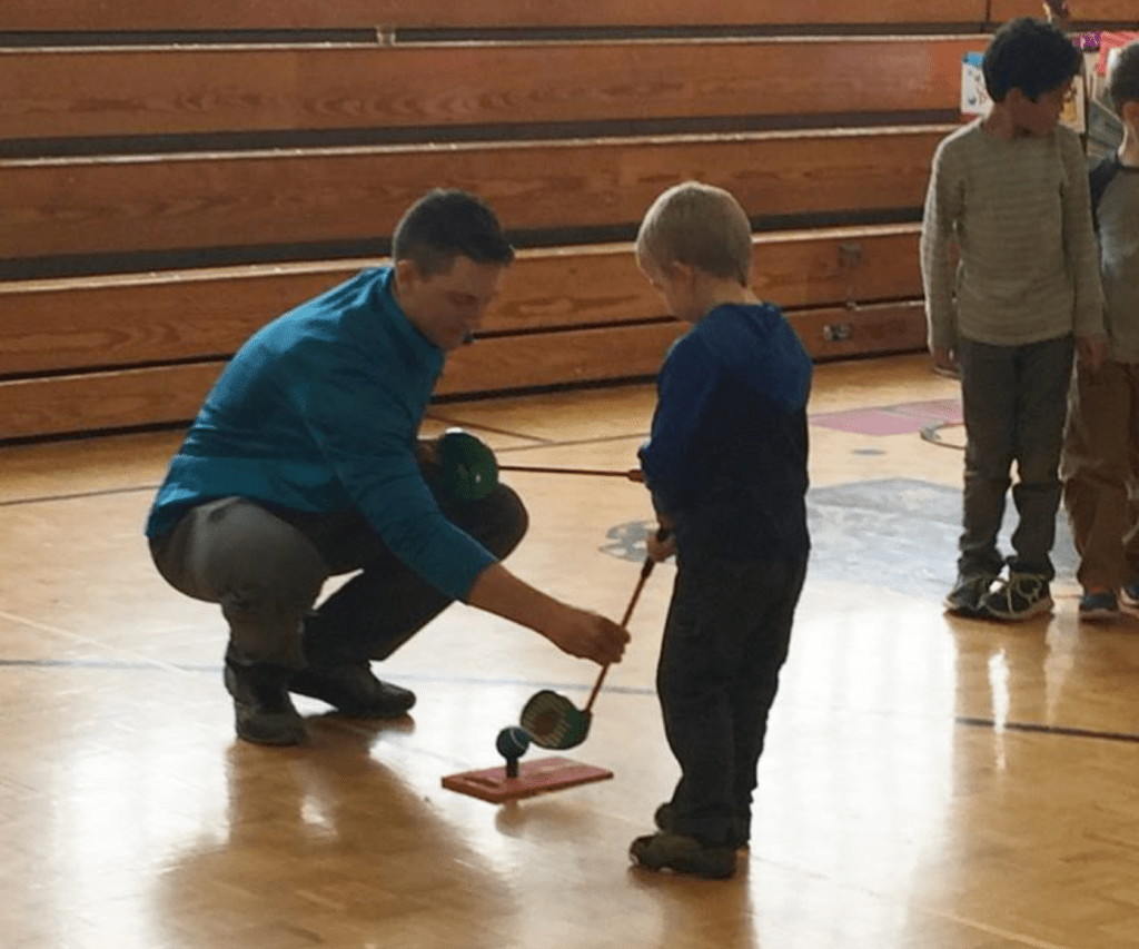 PGA coach Henry Fall gives junior golf lessons.